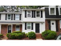 Charming two-story townhome with black shutters, brick stairs, and lush green landscaping at 7719 Kingsberry Ct, Raleigh, NC 27615