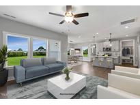 Bright living space with an open layout flowing into the kitchen and dining area, complemented by a ceiling fan at 89 Merle Way, Wendell, NC 27591