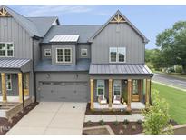 Stunning gray farmhouse-style home with a two-car garage, covered porch, and well-manicured landscaping at 1049 Coldspring Circle, Durham, NC 27705