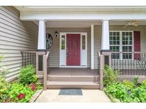 Inviting front porch with classic columns, decorative railings, and charming landscaping at 1601 Balkan Rd, Fuquay Varina, NC 27526
