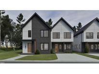 Modern townhome showcasing a stylish facade with a mix of light and dark gray materials and contrasting black trim at 1804 Pershing Rd, Raleigh, NC 27608