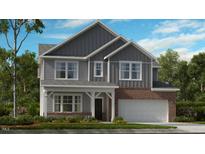 Charming two-story home featuring board and batten siding, a brick facade, and a welcoming covered front porch at 245 Tidal Pool Way, Cary, NC 27519