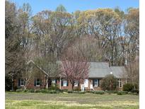 Charming brick home with lovely landscaping and a blooming tree in the front yard at 3110 Fieldstone Ln, Mebane, NC 27302