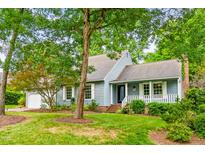 Charming home with mature trees, a brick chimney, and a well-manicured lawn at 318 Fieldstone Dr, Burlington, NC 27215