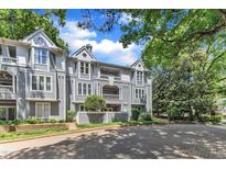 Charming gray condos boast balconies, brick walkways, and are surrounded by lush trees and blue skies at 700 Bishops Park Dr # 302, Raleigh, NC 27605