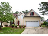 Charming two-story home features a well-manicured lawn, attached two-car garage, and inviting red front door at 10 London Way, Spring Lake, NC 28390