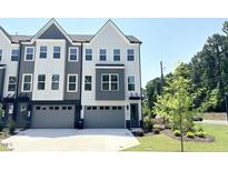 Modern townhome featuring a stylish gray and white exterior with ample windows and two-car garage at 1000 Regalia Rd # 1, Durham, NC 27713