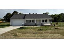 Charming single-story home featuring a welcoming front porch and attached garage at 111 Coharie Dr, Lillington, NC 27546