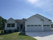 Charming single-Gathering home boasts a manicured lawn and an attached two-car garage at 111 Mahogany Way, Four Oaks, NC 27524