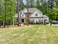 Beautiful two-story home featuring mixed brick and siding facade, well-manicured lawn and wooded background at 1218 Rogers Farm Rd, Wake Forest, NC 27587