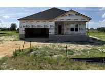New construction features a two-car garage and covered front porch at 136 Tuskeegee Dr, Smithfield, NC 27577