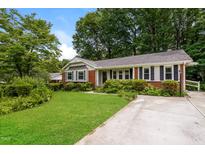 Charming one story home with brick accents, black shutters, established shrubs and manicured lawn at 1405 Kenbrook Dr, Garner, NC 27529