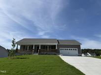 Charming single-story home features a welcoming front porch and attached two-car garage at 152 Tulipfield Way, Benson, NC 27504