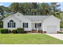 Charming single-story home featuring a well-maintained lawn, attached garage, and inviting front porch at 1752 Cobblestone Dr, Creedmoor, NC 27522