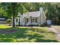 Charming single-story home featuring a well-manicured lawn and mature trees at 2213 Stephanie Ln, Clayton, NC 27520