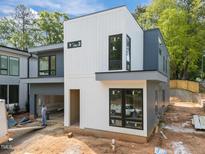 Modern new construction with white and gray siding, black frame windows, and an attached two-car garage at 2321 Turners Aly, Raleigh, NC 27607