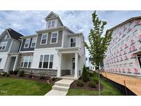 Charming two-story home with stone accents, covered porch, and well-maintained landscaping at 2411 Whitewing Ln, Wendell, NC 27591