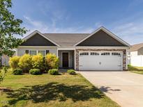Charming single-story home featuring a two-car garage, well-maintained lawn, and stone accents at 304 Anaconda Trl, Mebane, NC 27302