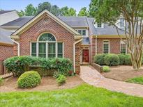 Charming brick home featuring a landscaped front yard and a welcoming brick pathway to the red front door at 3347 Ridgecrest Ct, Raleigh, NC 27607
