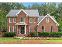 Charming two-story brick home with manicured landscaping and a welcoming front entrance at 4412 Thistlehill Ct, Raleigh, NC 27616