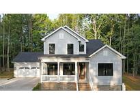 Charming two-story home with a covered porch and attached two car garage at 5491 Silk Hope Gum Springs Rd, Siler City, NC 27344