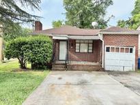 Classic brick home with an attached garage and tidy front yard at 628 Massey Ave, Durham, NC 27701