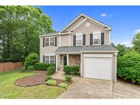 Charming two-story home with neutral siding, stone accents, attached garage and well manicured landscaping at 105 Walehurst Ridge Dr, Angier, NC 27501