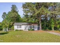 Charming single-story home with a white exterior and a well-manicured lawn at 1109 N Pinkston St. St, Henderson, NC 27536