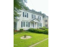 Charming two-story home with a well-manicured front yard featuring green lawn and mature bushes at 112 E Sycamore St, Zebulon, NC 27597