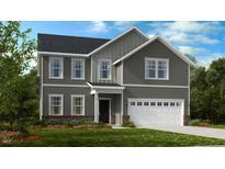 Charming two-story home with gray siding, a white two car garage, and a manicured front yard at 1128 Sun Springs Rd, Wake Forest, NC 27587
