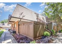 Exterior view of townhouse featuring a brick facade, a private wooden fenced patio, and well-maintained landscaping at 119 Brookberry Cir, Chapel Hill, NC 27517