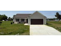 Charming single-story home with neutral siding, attached garage, and well-manicured lawn at 128 Coharie Dr, Lillington, NC 27546