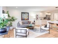 Bright living room with stylish gray sofa, modern art, and adjacent kitchen, perfect for entertaining at 1309 Hudson Ave # D12, Durham, NC 27705