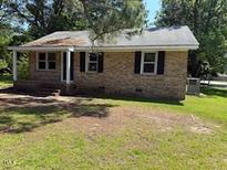 A charming brick home with a well-maintained lawn and inviting front porch at 1525 Hargrove St, Rocky Mount, NC 27801