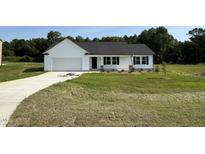 Charming single-story home featuring a classic white facade, a two-car garage, and a neatly maintained lawn at 179 Coharie Dr, Lillington, NC 27546