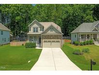Charming two-story home featuring a two-car garage, well-manicured lawn, and inviting curb appeal at 240 Paddy Ln, Youngsville, NC 27596