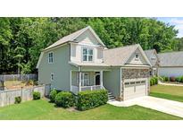 Charming two-story home with stone accents, a cozy front porch, and a lush green lawn at 240 Paddy Ln, Youngsville, NC 27596