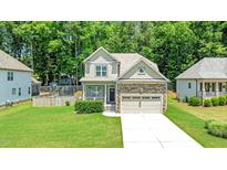 Charming two-story home with stone accents, manicured lawn, and an attached two-car garage at 240 Paddy Ln, Youngsville, NC 27596