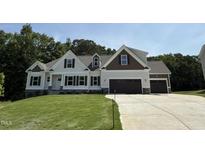 Beautiful new construction home featuring two-tone siding and a three-car garage at 322 Busterfield Ct, Benson, NC 27504