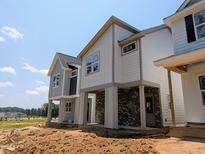 Modern two-story home with brick foundation, gray siding, and covered porch, set against a clear blue sky at 330 Cottage Hill Way, Knightdale, NC 27604