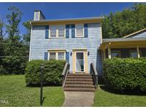 Charming blue two-story home with yellow trim, blue shutters, brick steps, and green landscaping at 3510 Rawdon Dr, Durham, NC 27713