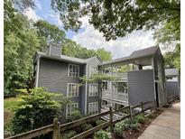 Three story exterior view of building with gray siding and upper level outdoor walkways at 4120 Sedgewood Dr # 106, Raleigh, NC 27612