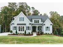 Charming light-blue home with manicured lawn, covered porch, and tasteful landscaping at 46 Addison Pond Ct, Zebulon, NC 27597