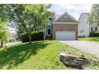 Charming brick home featuring a well-manicured lawn and attached two car garage at 5501 Southern Cross Ave, Raleigh, NC 27606