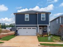 Charming two-story home featuring a blue exterior and a two-car garage, enhanced by a neatly manicured lawn at 825 Ottawa Dr, Garner, NC 27529