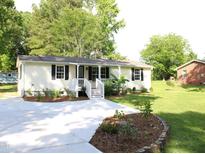 Charming home featuring fresh landscaping, a cozy front porch, and a new driveway at 10180 Buffalo Rd, Clayton, NC 27527
