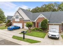 Charming brick townhome with a well-manicured lawn, colorful flower beds, and a two-car garage at 10404 Dapping Dr, Raleigh, NC 27614