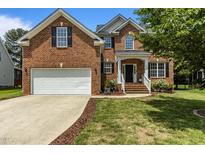Charming two-story brick home with a well-manicured lawn and a two-car garage at 110 Fairchild Downs Pl, Cary, NC 27518