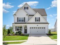 Charming two-story home with a manicured lawn, attached garage, and classic architectural details at 1101 Hazelmist Dr, Youngsville, NC 27596