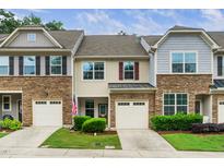 Townhome exterior features stone accents, attached garages, and well-maintained landscaping at 114 Constitution Dr, Durham, NC 27705